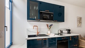 Eine moderne Küche mit dunkelblauen Schränken, einer weißen Arbeitsplatte und einem eingebauten Backofen.