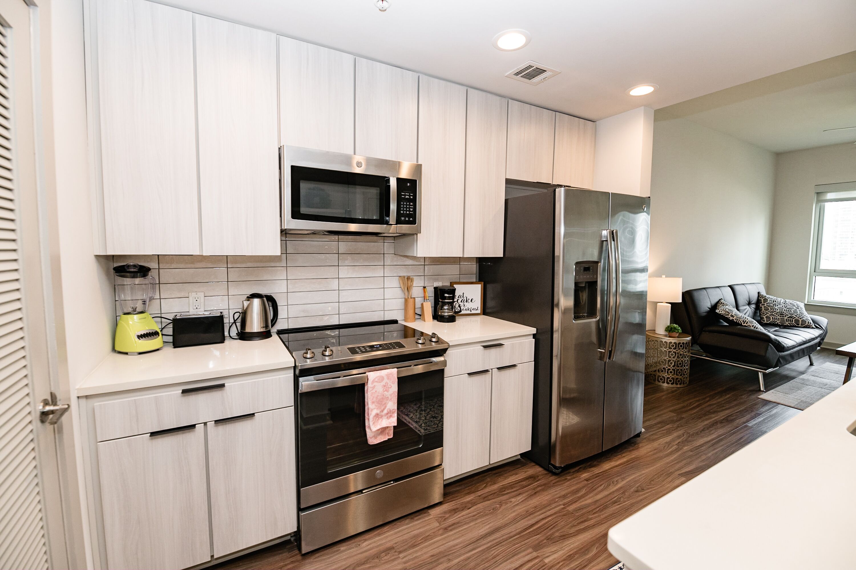 A modern kitchen with stainless steel appliances, light wood cabinets, and a clean, minimalist design.