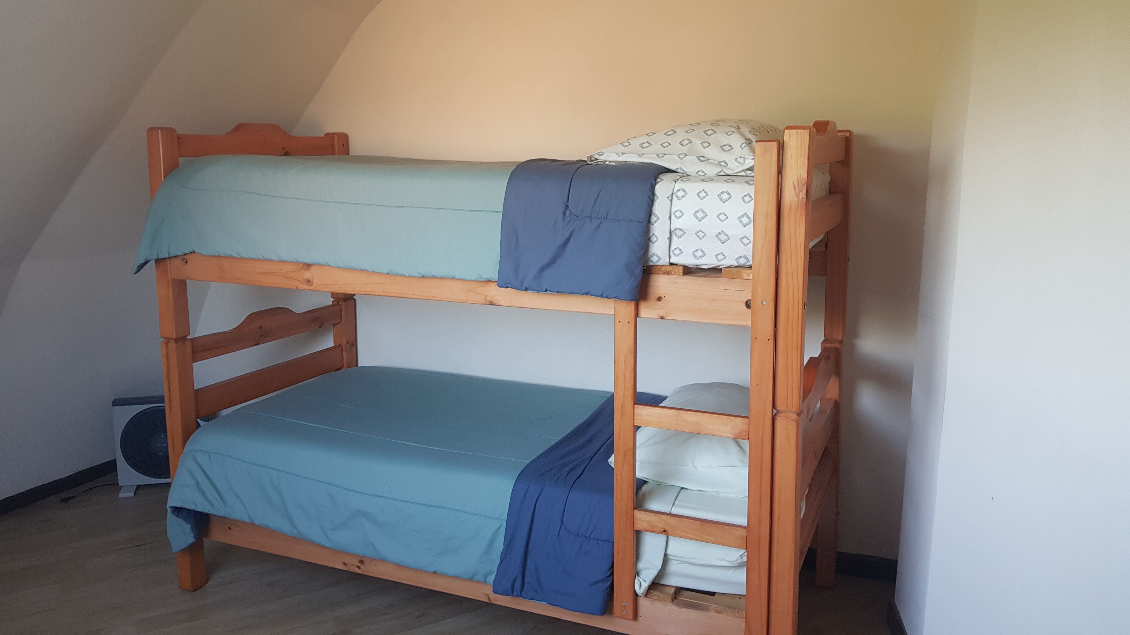 Una cama litera con dos niveles, cada uno con un colchón y una manta.