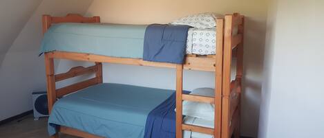 Una cama litera con dos niveles, cada uno con un colchón y una manta.