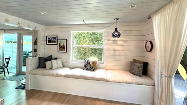 A cozy room with a built-in bench along a window, a dining area with a table and chairs, and a ceiling with recessed lighting. - Casa Marina Cottage+ private pool+walk to Duvall st. (Key West)