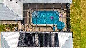 An aerial view of a house with a swimming pool, solar panels, and a small garden area. - 3/2 updated pool home that sleeps 8 about 5 minutes from WEC (Ocala)