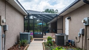 A covered outdoor area with a pool, air conditioning units, and a garden pathway. - 3/2 updated pool home that sleeps 8 about 5 minutes from WEC (Ocala)