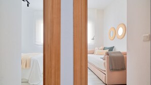 Un dormitorio moderno con una cama, un sofá y dos espejos redondos en la pared.