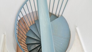 Una escalera de caracol con barandilla azul y escalones de madera.