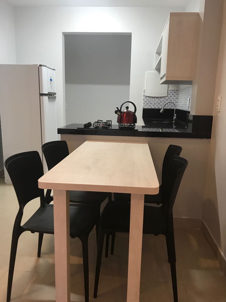 Eine kleine Küche mit Essbereich, Kühlschrank, Wasserkocher und Kaffeemaschine.