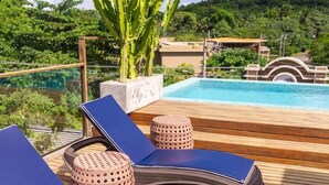 Eine Holzterrasse mit Liegestühlen und einem Kaktus.