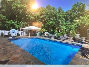 Relax by the pool surrounded by lush greenery and comfortable lounge chairs.