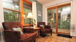 Ein gemütliches Wohnzimmer mit zwei braunen Ledersofas, einem kleinen runden Tisch und einer Lampe.