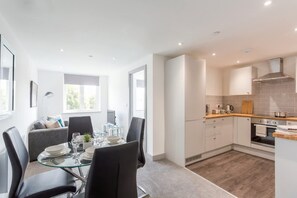 A modern kitchen with white cabinets, a wooden countertop, and a built-in oven. - Bright & Modern 1 Bedroom Apartment in Leeds (Leeds)