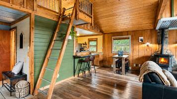 L’intérieur d’une cabane comprend un espace nuit en mezzanine, un coin repas et un poêle à bois.