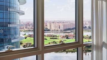 Un bâtiment moderne doté de grandes fenêtres donnant sur un paysage urbain et une rivière.