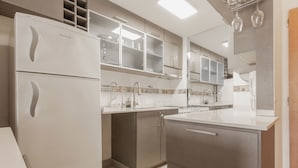 A modern kitchen with a refrigerator, cabinets, and a countertop. - Departamento moderno (Buenos Aires)