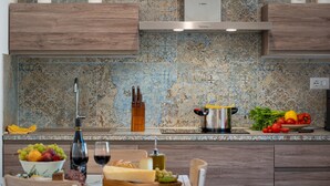 A modern kitchen with a wooden countertop, a stainless steel pot, and a variety of fresh produce. - Villa Cristina 3, Emma Villas (Marliana)