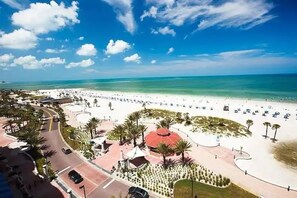A beachside resort with a central pavilion, palm trees, and a clear view of the ocean. - Beautiful GROUND FLOOR condo 2 br /2 ba AVALON (Clearwater)