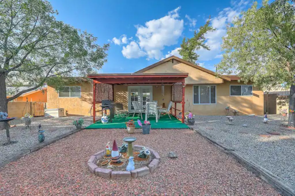 A house with a patio, a small fountain, and a covered outdoor seating area.