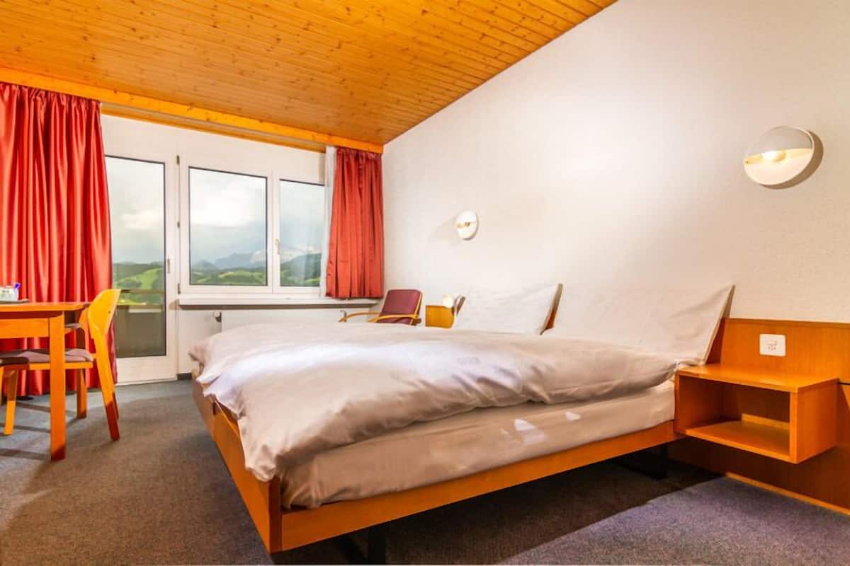 Ein Schlafzimmer mit einem hölzernen Bett, einem Schreibtisch und einem Stuhl.