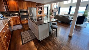 A modern kitchen with wooden cabinets, stainless steel appliances, and a large island. - Stoweic Views  - Luxury Dream Vacation Home (Stowe)