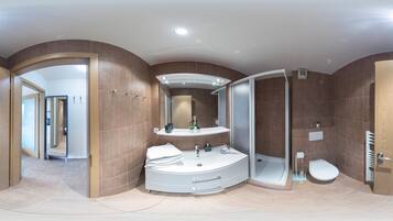 Enjoy a spacious bathroom with a central sink, walk-in shower, and ample storage for toiletries.