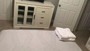 A bedroom with a bed, a white dresser with a television on top, and a door. - NEAR TX A&M, HWY 6 , NO CLEANING FEE ,ENTIRE PLaCE (College Station)