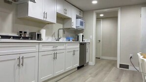 A modern kitchen with white cabinets, a microwave, a toaster, and a dishwasher. - Quiet and cosy get away suite in Point Grey Vancouver BC, near UBC and beach. (Vancouver)