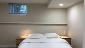 A bedroom with a bed, bedside tables, and a window. - Quiet and cosy get away suite in Point Grey Vancouver BC, near UBC and beach. (Vancouver)