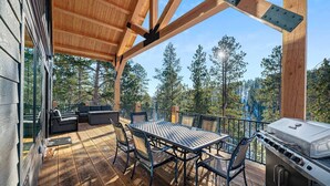 An outdoor deck with a dining table and chairs, a grill, and a sofa area. - Valley Vista Retreat - New 5BR Cabin (Lead)