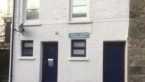 En toetages bygning med et skilt der viser 'Heol y Graig Graig Road'.