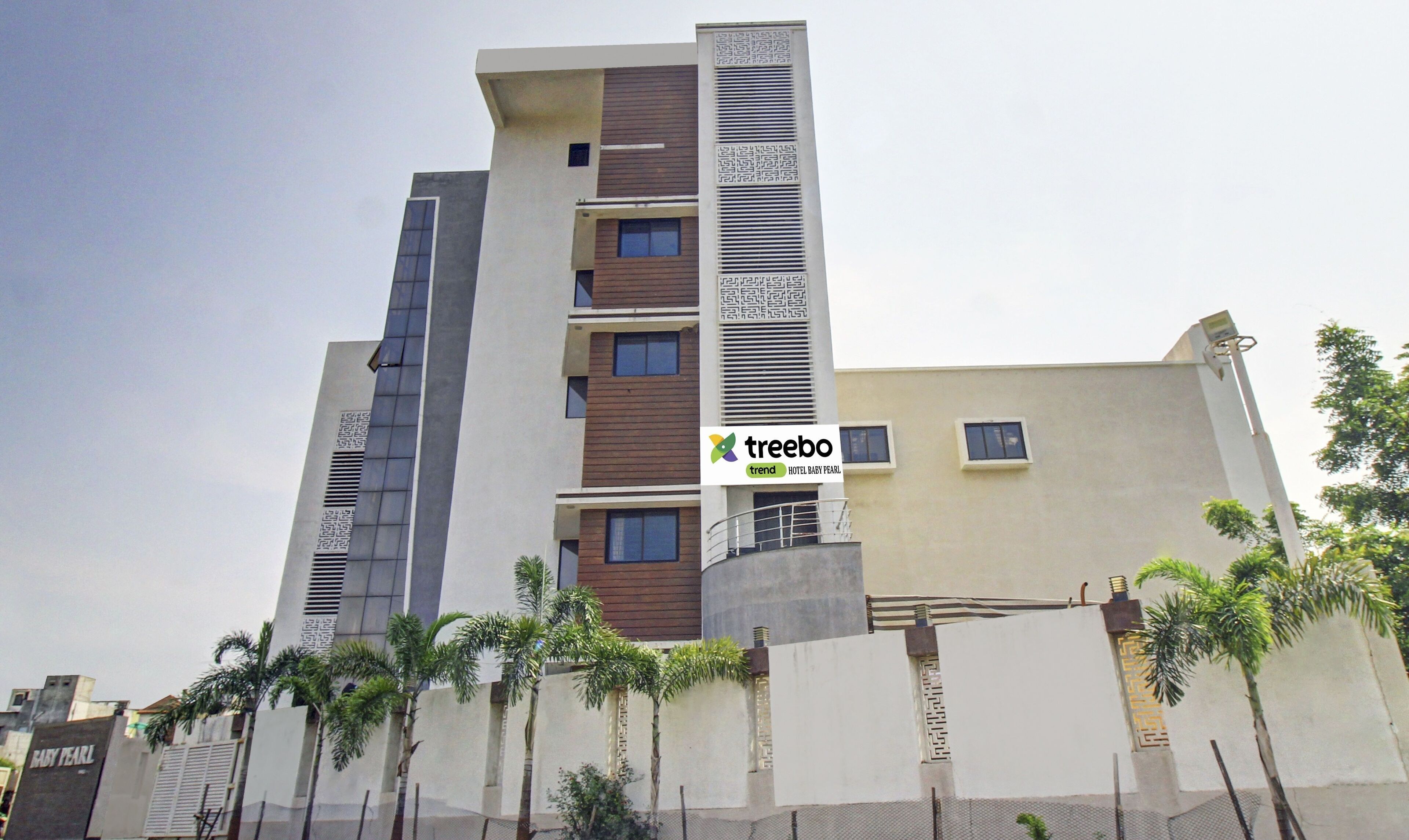 A multi-story hotel with a modern design, featuring a prominent logo on the facade.
