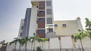 A multi-story hotel with a modern design, featuring a prominent logo on the facade.