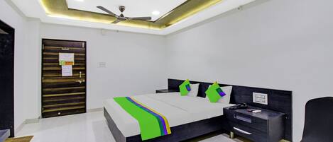 A modern bedroom with a bed, bedside table, and a desk.