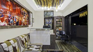 A reception area with a sofa, a desk, and a bookshelf. - Treebo Baby Pearl (Amravati)