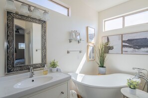 A bathroom with a large mirror, a sink, a bathtub, and two potted plants. - Beautiful Cave Creek 3 Bdrm home in Quiet Area! (Cave Creek)
