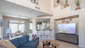 A modern living room with a gray sofa, a coffee table, and a TV on a cabinet. - Beautiful Cave Creek 3 Bdrm home in Quiet Area! (Cave Creek)