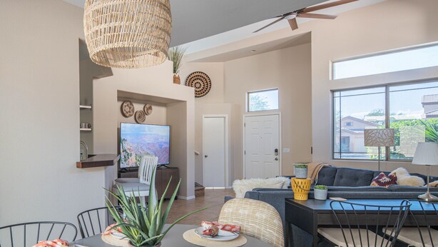A dining area with a table set for two, a television, and a sofa in the background. - Beautiful Cave Creek 3 Bdrm home in Quiet Area! (Cave Creek)