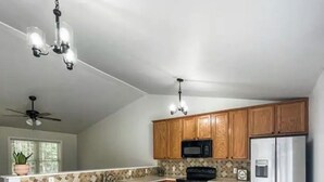 A kitchen with wooden cabinets, a stainless steel refrigerator, a microwave, and a dishwasher.