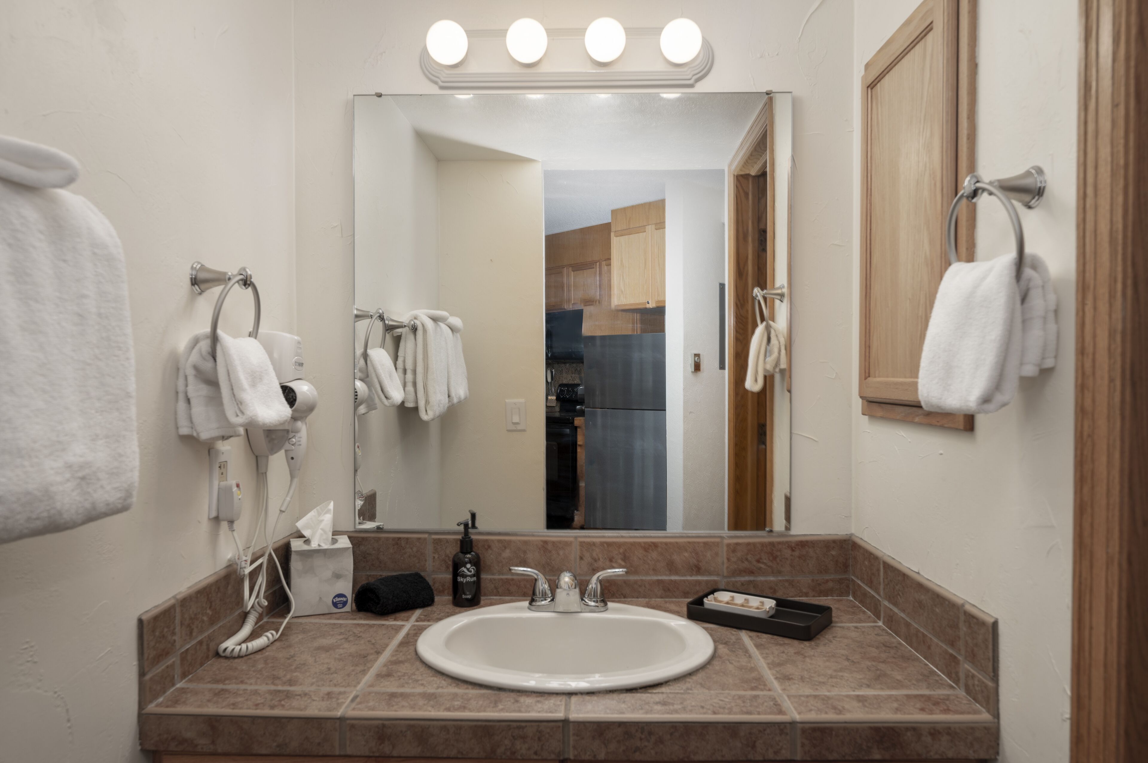 A bathroom with a sink, mirror, and towel rack.