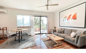 Relax and socialize in this spacious living area with a sofa, coffee table, and dining space.