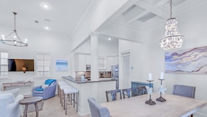 A spacious kitchen with a central island, white cabinetry, and a dining area with a large table and chairs. - 🐟Three Master Suites- Pet Friendly-Seas the Day on 30A (Santa Rosa Beach)