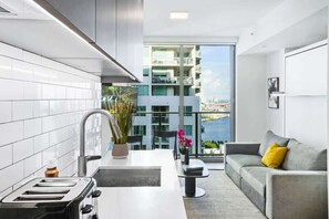 Cocina moderna con vistas a un edificio alto y un balcón.