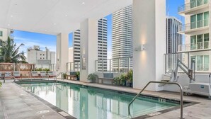 Une piscine intérieure offrant une vue dégagée sur les grands immeubles qui se dressent à l’arrière-plan.