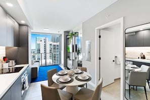 Cozinha moderna com área de jantar, vista da cidade e varanda.