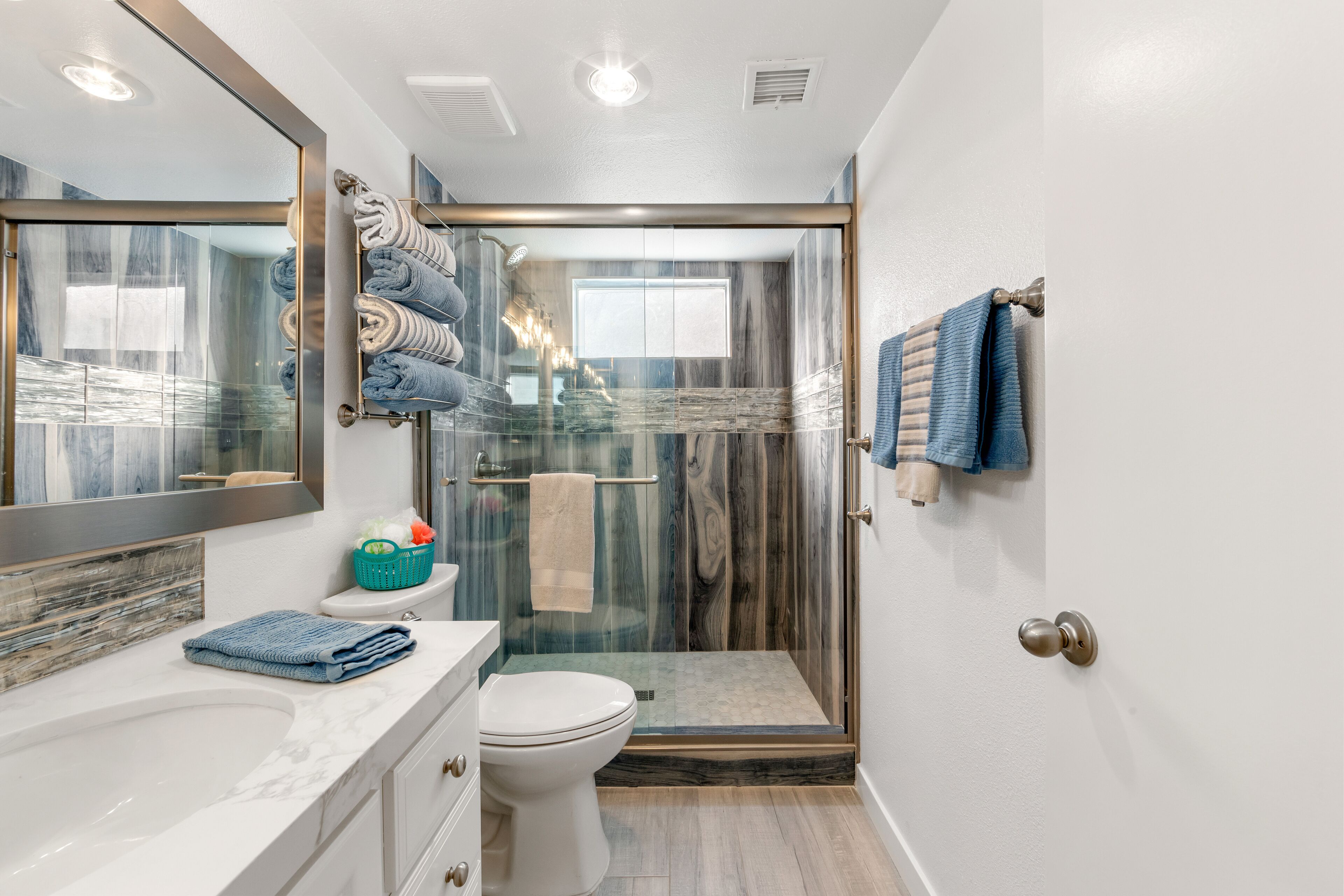 Une salle de bain moderne avec une douche à parois de verre, un lavabo en marbre et des toilettes.