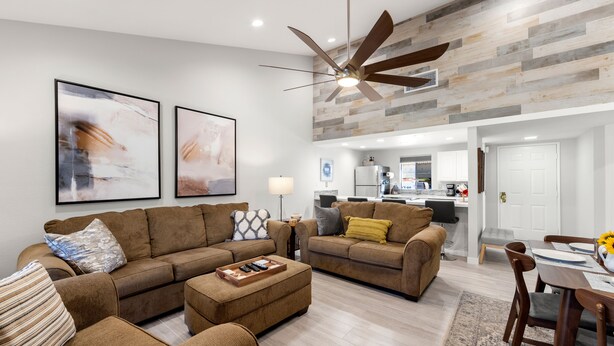 A modern living room with two sofas, a coffee table, and a dining area with a table and chairs. - Luxurious Fairway Condo Resort (Palm Desert)