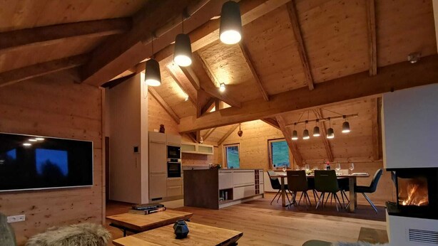 Un intérieur chaleureux et rustique, avec un espace repas, une cuisine et un salon.