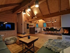 Un interior acogedor de madera, con comedor, cocina y sala de estar.