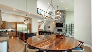 Una cocina amplia con una isla grande, armarios de madera y una lámpara de techo moderna.