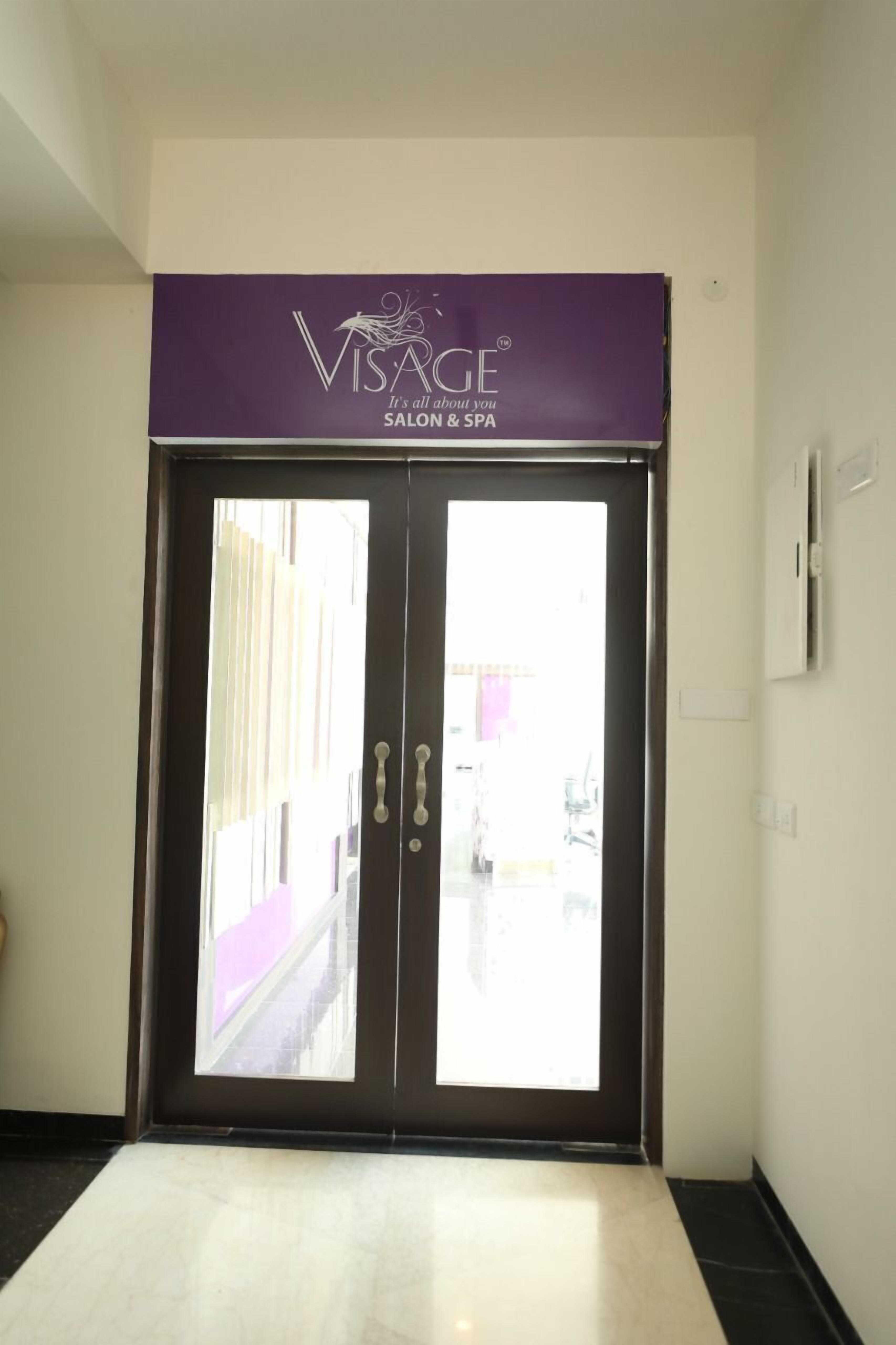 A double door entrance with a purple sign above it reading "VISAGE Salon & Spa".