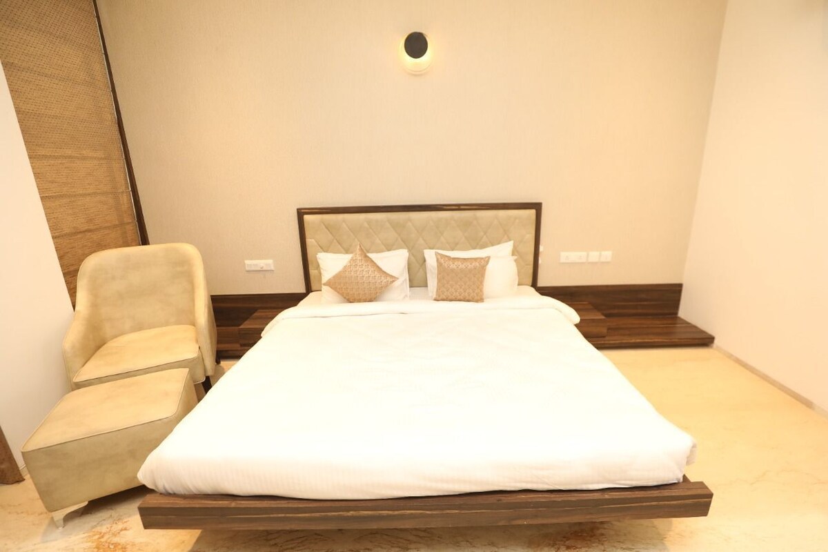 A neatly arranged bedroom with a bed, a chair, and a small table.