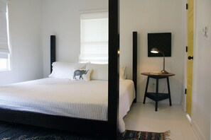 A bedroom with a bed, a bedside table with a lamp, and a window with blinds. - Amazing Location- Paseo Arts/NW23 Restaurants/Entertainment (Oklahoma City)